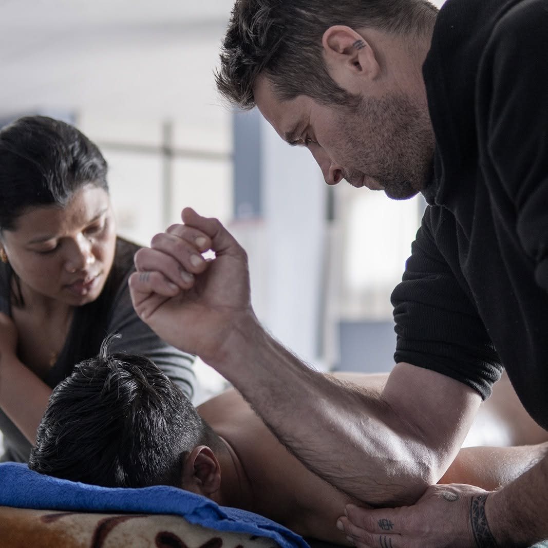 Students practising a deep tissue massage technique