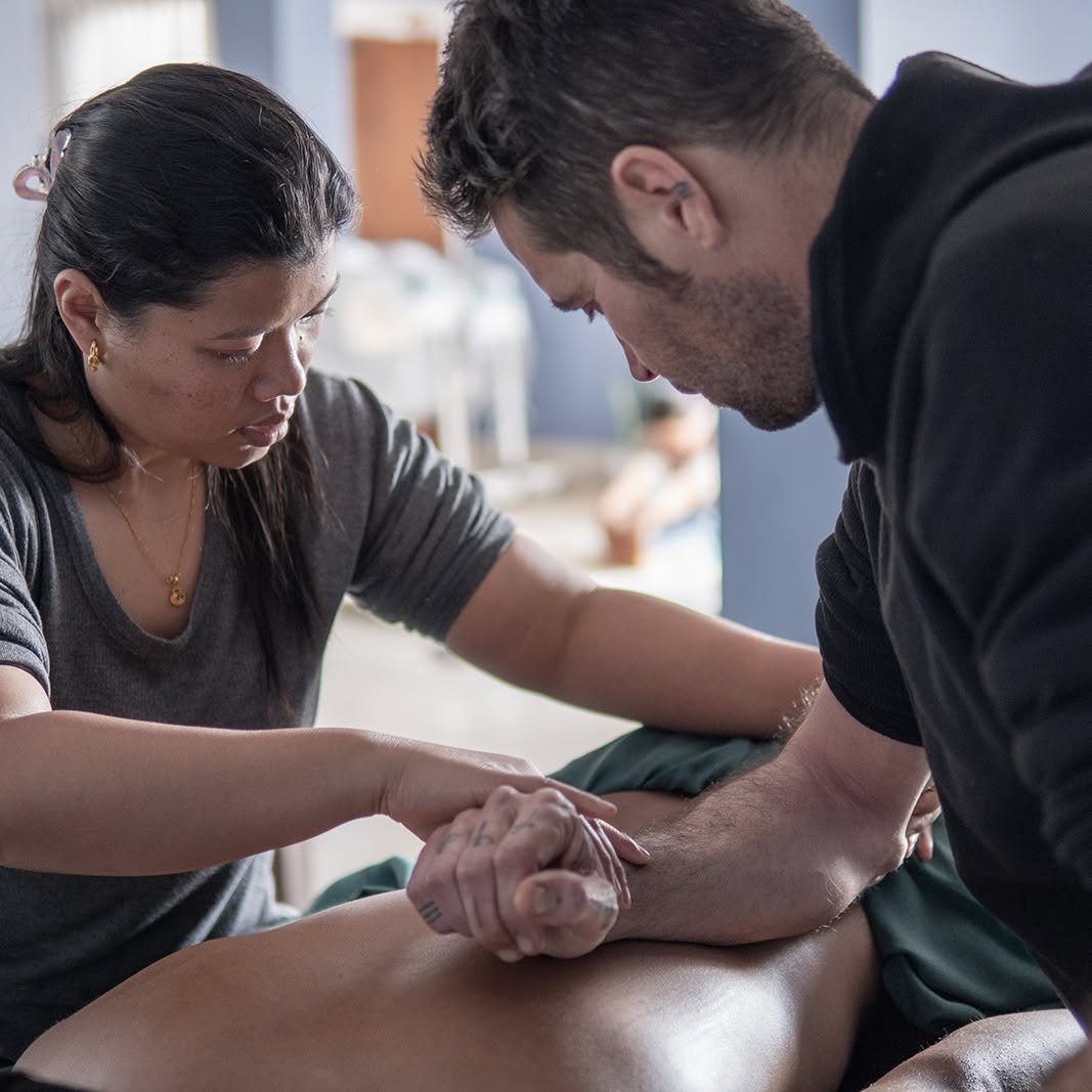 Students receiving guided practical massage training at AIPA